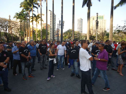 Manisfestantes do lado de fora, ouvindo a voz dos dirigentes